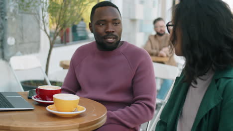 African-American-Man-Talking-with-Female-Colleague-on-Coffee-Break-in-Outdoor-Cafe